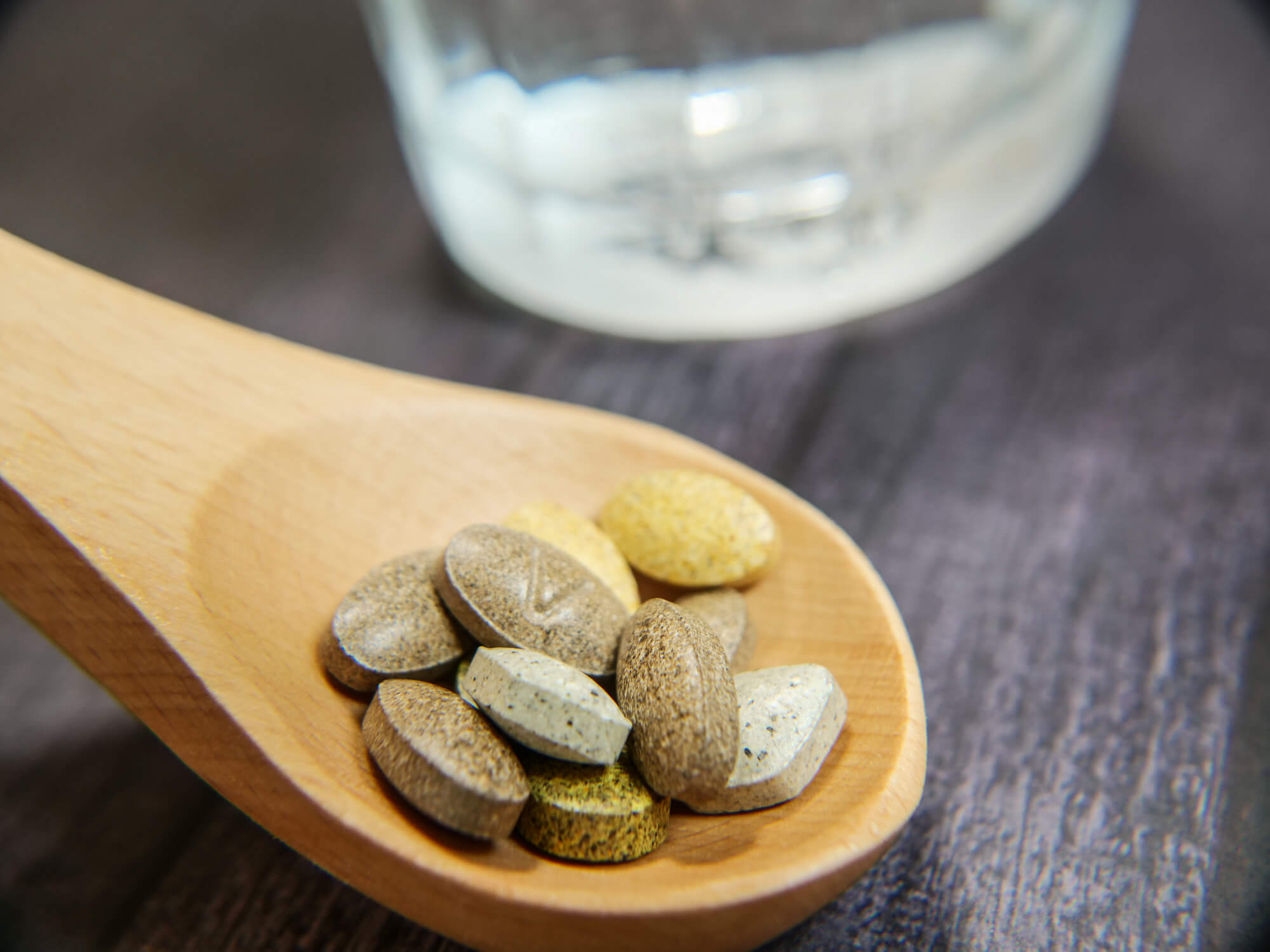 木製のスプーンの上に乗っているサプリ