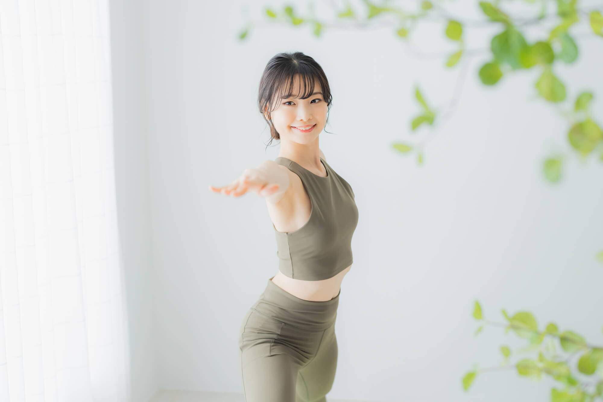 スポーツウェアを着て室内で体を動かす女性