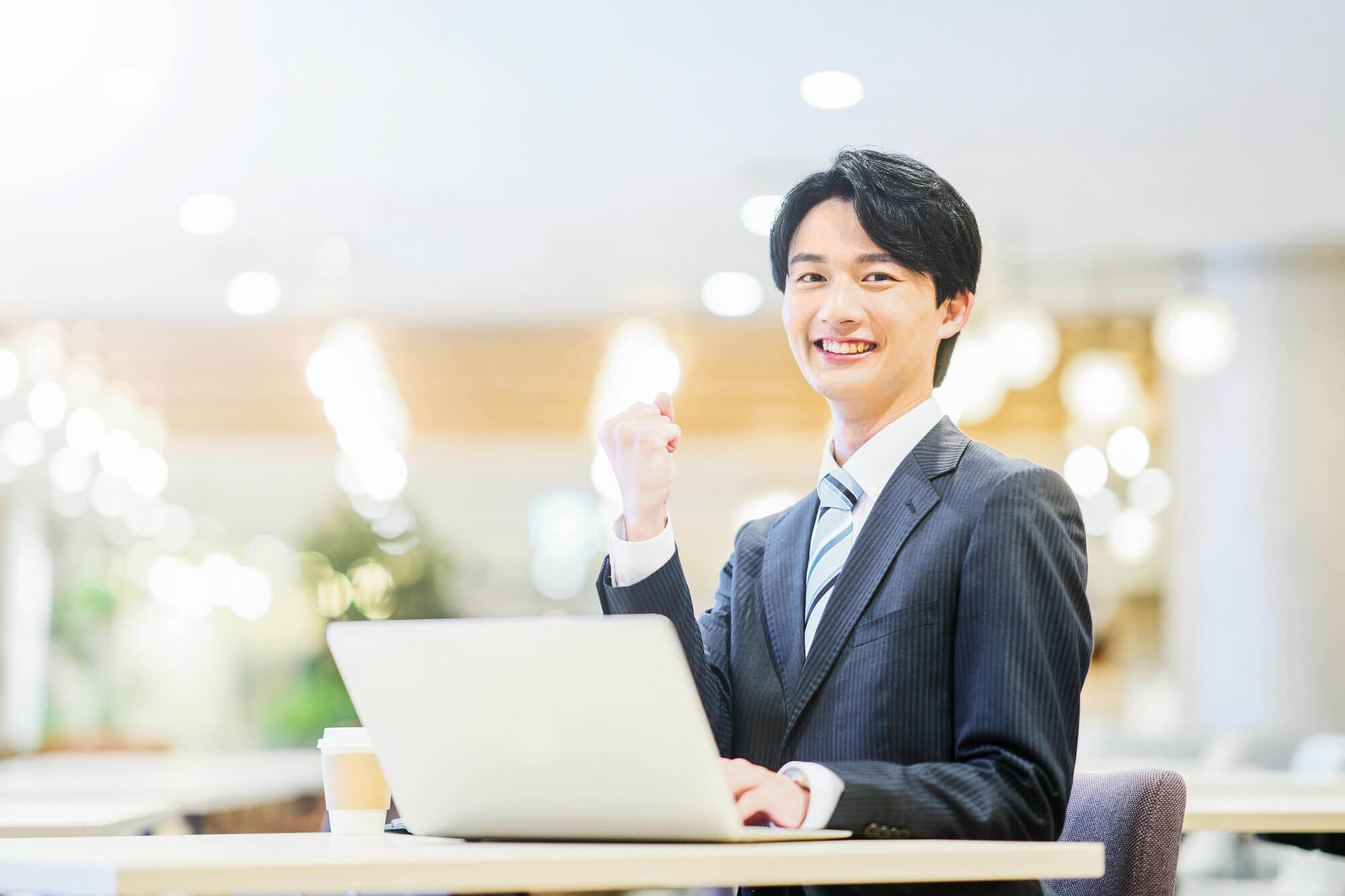 やる気に満ちた様子でガッツポーズをするビジネスパーソン