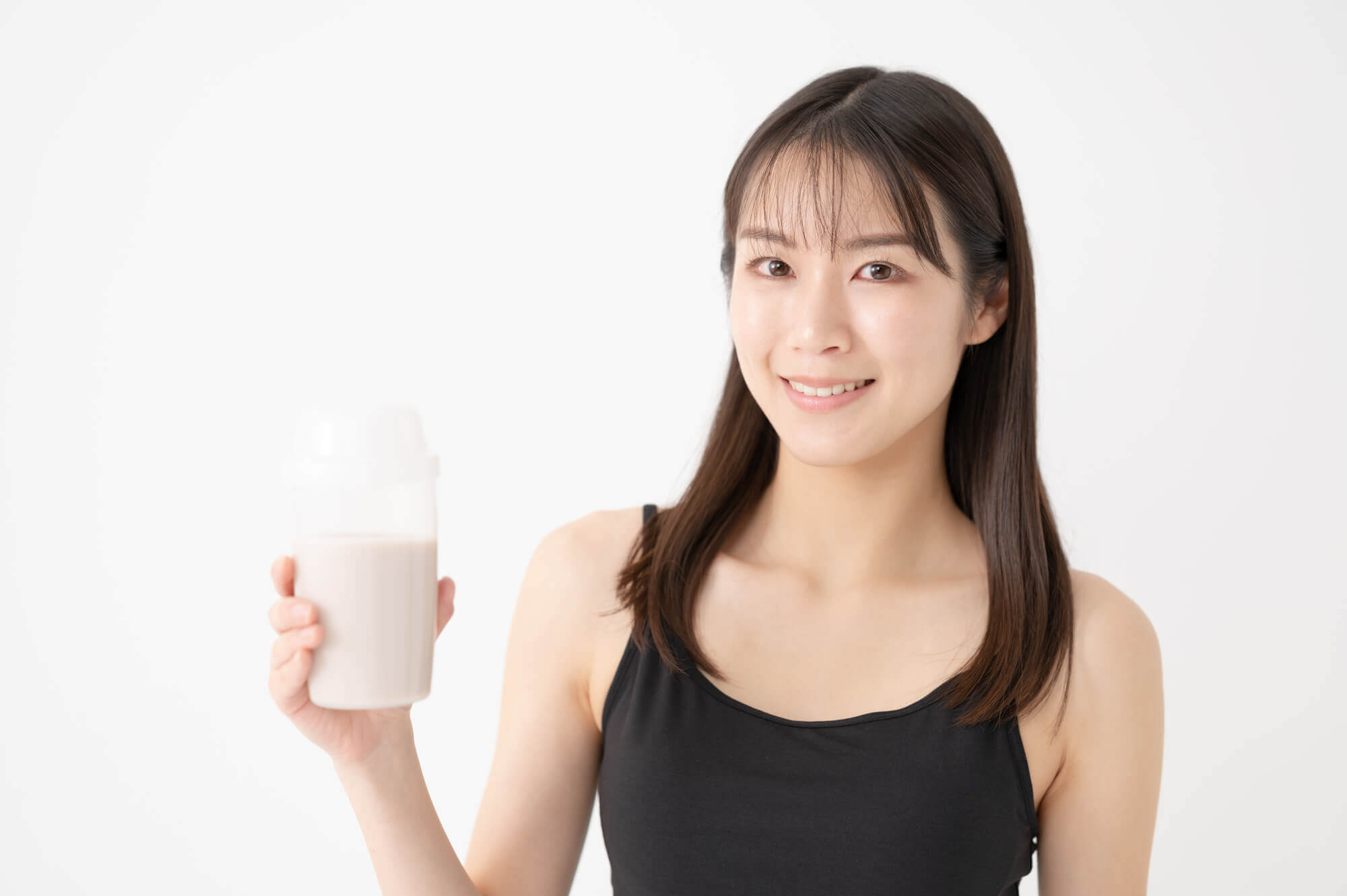 プロテインを飲んでいるスポーツウェアの女性