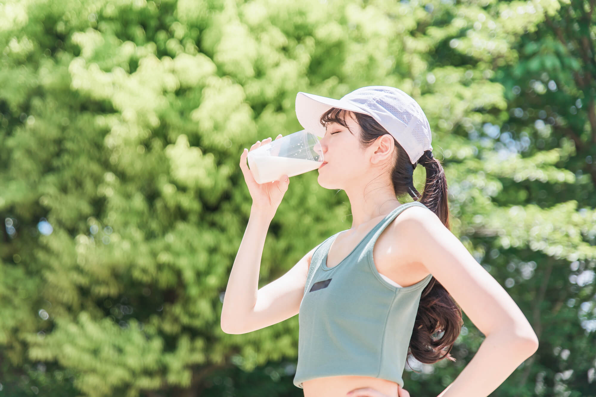 公園でプロテインを飲む女性
